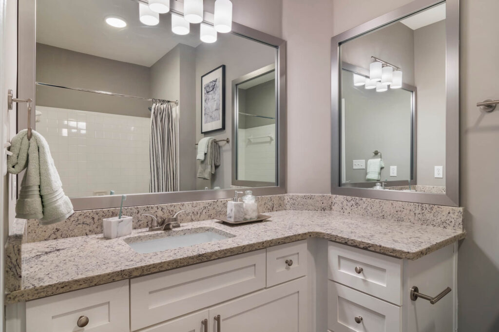 Bathroom with granite counters and two mirrors