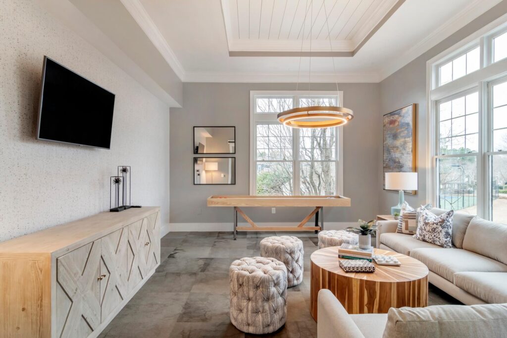 Clubhouse game room with lounge seating, TV, and shuffleboard table