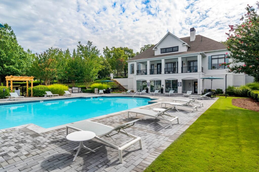 Pool deck with view of 2 story clubhouse