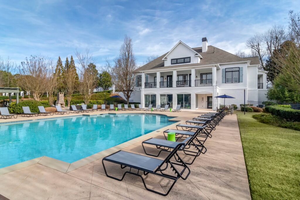 Pool deck with covered and uncovered seating and view of clubhouse
