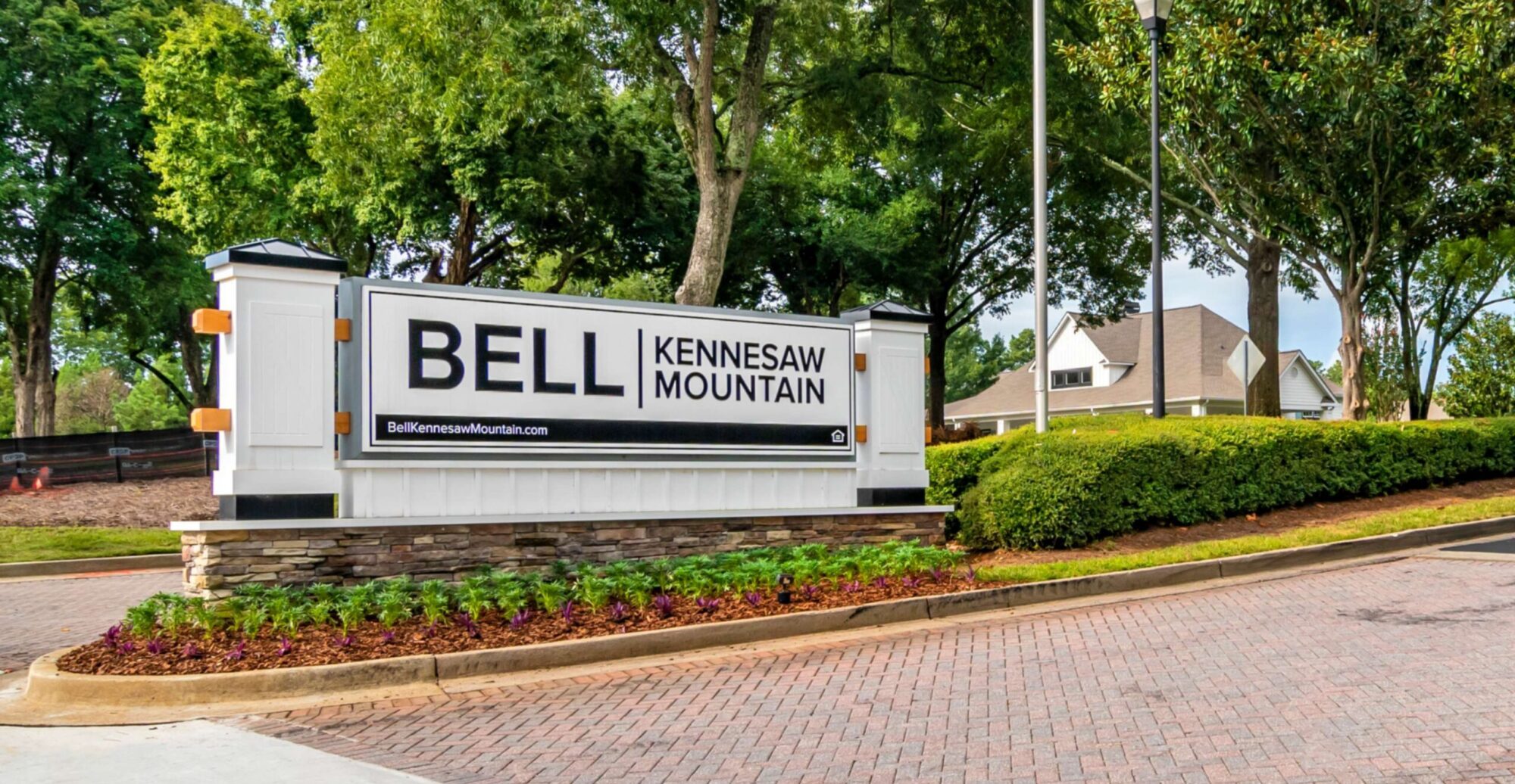 Property signs that reads, "Bell Kennesaw Mountain," surrounded by trees and landscaping